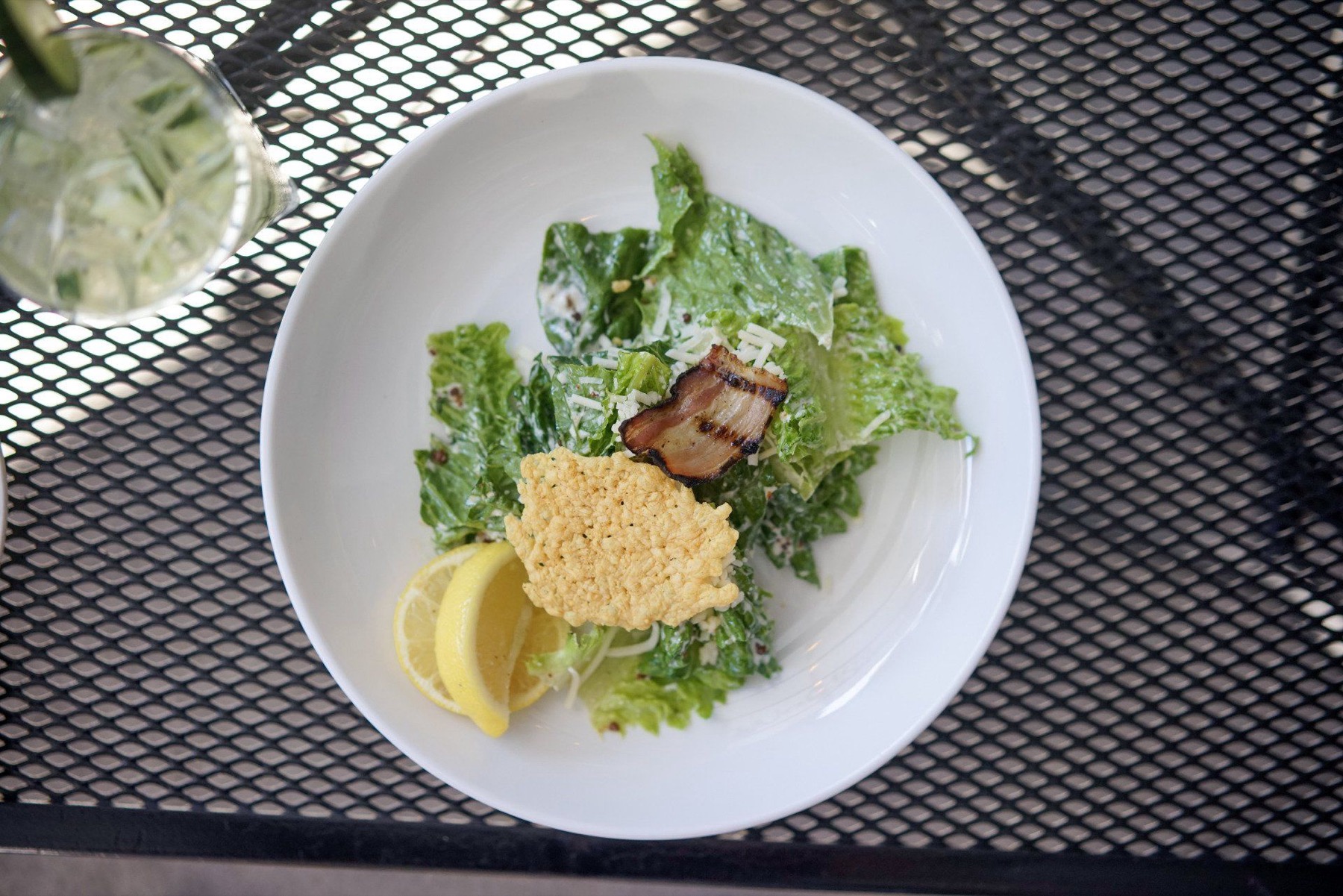 A Caesar salad and a cocktail on the sunny patio