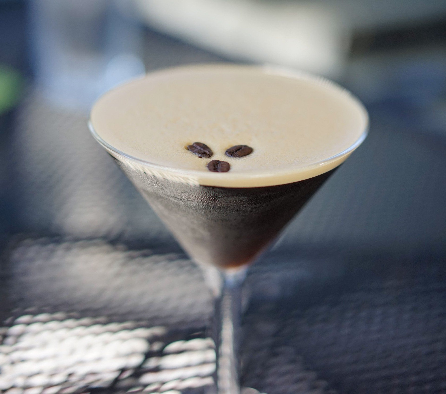 An espresso martini garnished with coffee beans