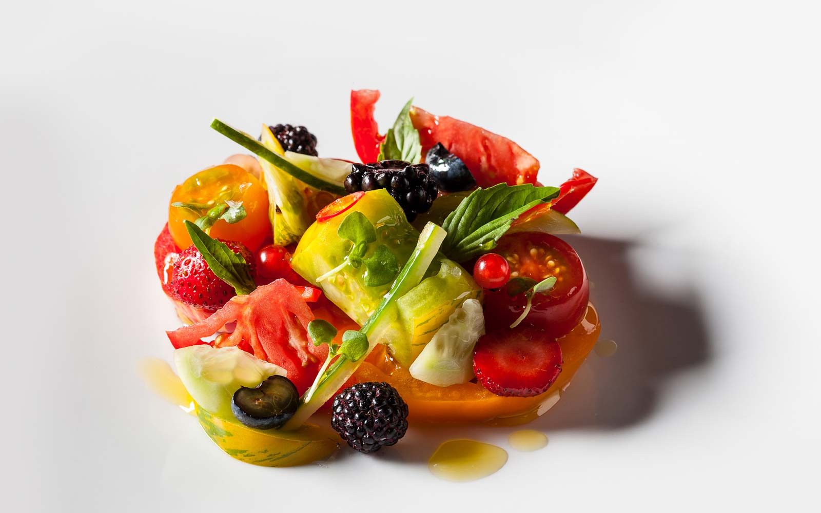 Heirloom tomatoes, berries, cucumber and basil in olive oil