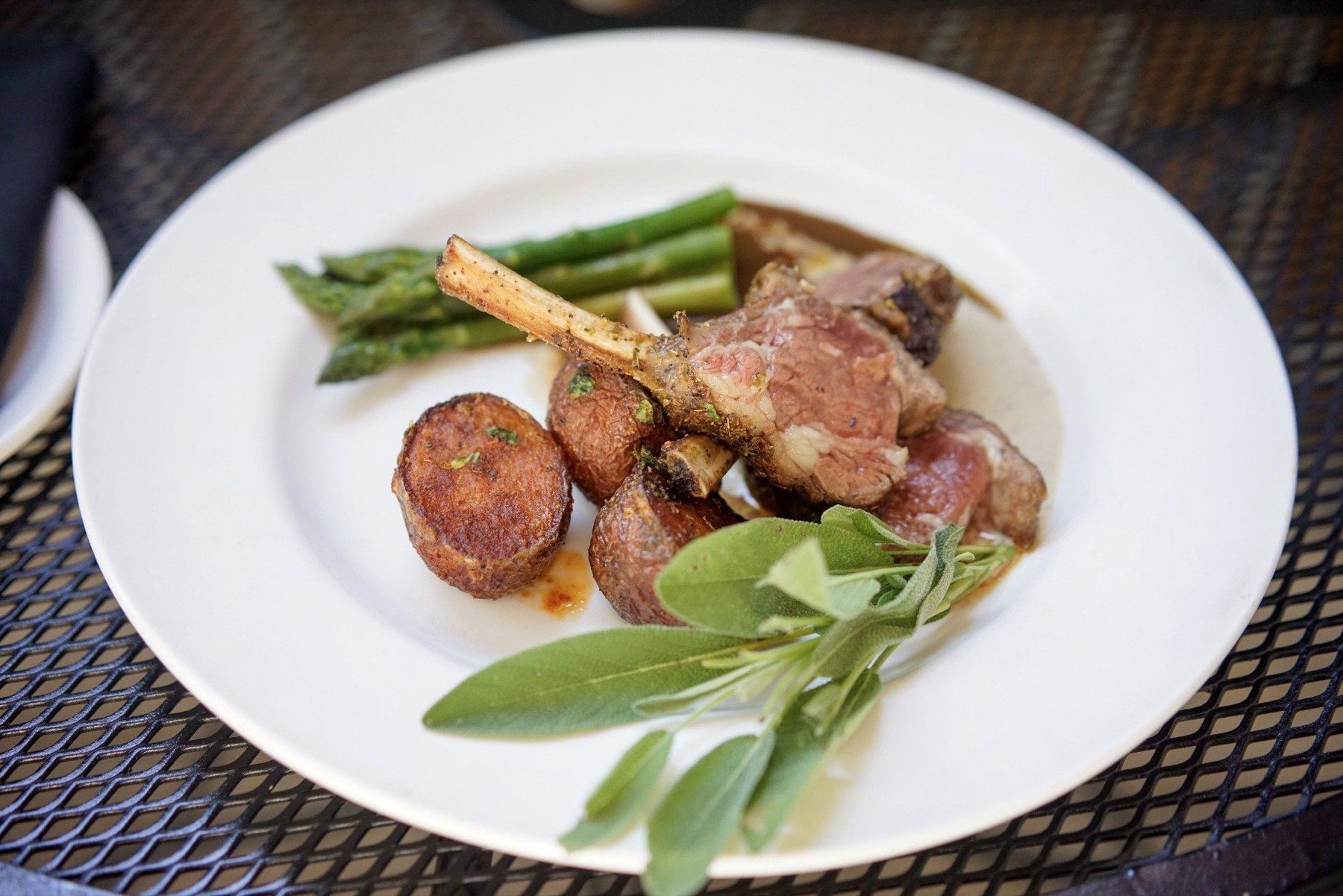 Roast rack of lamb with asparagus, potato croquettes, fresh sage and a red wine demi-glace