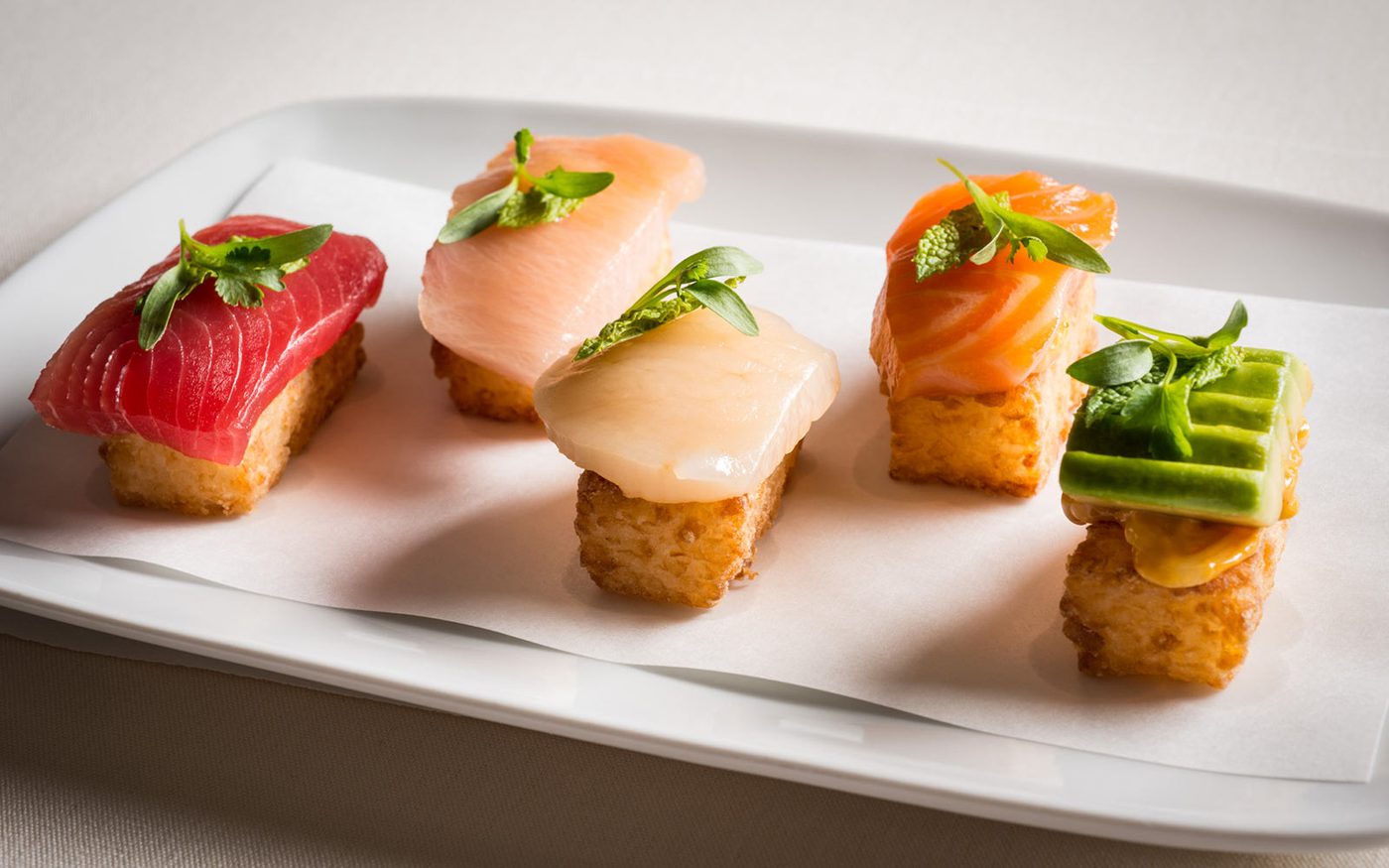 Crispy rice bites topped with tuna, hamachi, scallop and salmon